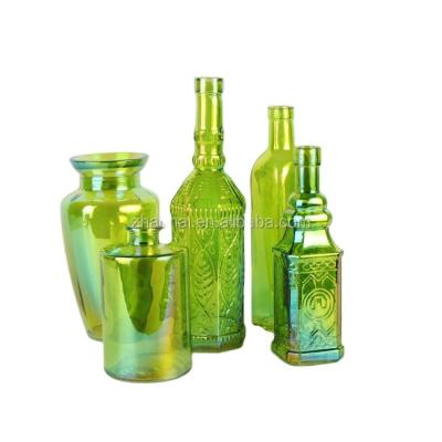 China Classic Green Colored Glass Vase Embossed Bottle Centerpieces Supplier for sale