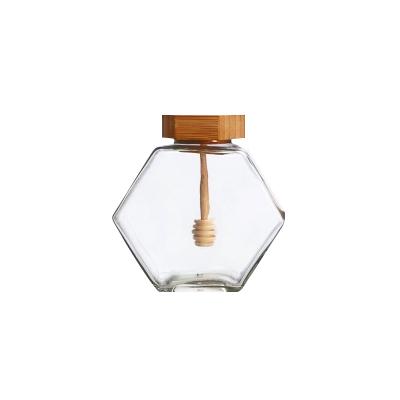 China Custom Clear Hexagon Food Honey Condiment Serving Spice Herb Glass Storage Jar With Wooden Lid And Plunger for sale