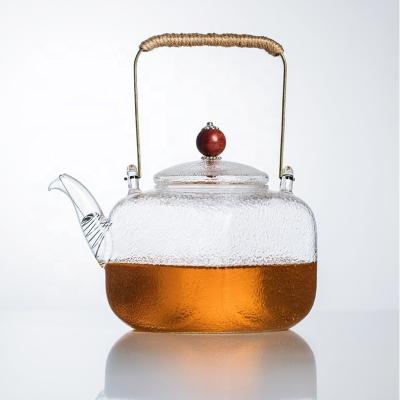 China New Design Environmentally Sustainable Hammer Grain Shape Glass Transparent Square Teapot With Glass Infuser And Copper Handle for sale