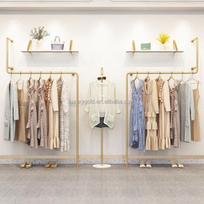 China Clothing Store Fashion New Product Design Exquisite Decorative Shiny Gold Metal Hanging Shelves For Wall Stainless Steel Female Clothes Rack for sale