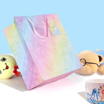 China Custom Materials Logo Recycled Holiday Rainbow Color Paper Bag Clothing Shopping Bag Reusable Gift Packaging With Rope Handle For Cosmetics for sale