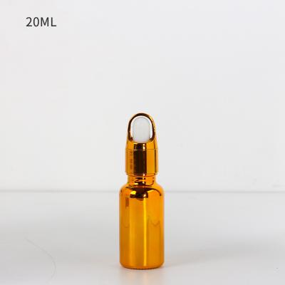 China Cosmetic Luxury Gold Essential Oil Glass Bottle Dropper Round Plating Gold Essence Glass Bottle for sale