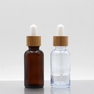 China Screen printing amber cosmetic glass frosted essential oil glass bottles with bamboo dropper bottle for sale