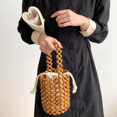 China Fashion Dealing Summer Niche Ladies Bucket Bag Portable Drawstring Bag Fashion Wooden Bead Beach Bag for sale