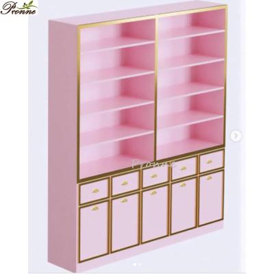 China Simple And Modern Beauty Salon Floor Standing Customized Makeup Wooden Pink&Gold Cosmetic Display Cabinet Showcase for sale