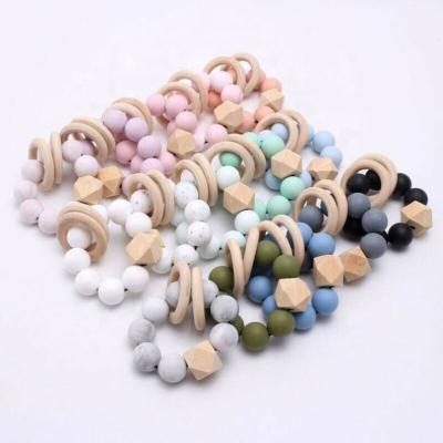 China Toy Wholesale Baby Chewable Soft Silicone Bead Teething Ring Rattles Toys Wooden Teether Bracelet for sale