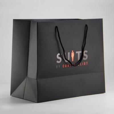 China Luxury Matte Handled Black Shopping Paper Bag With Embossing Logo For Apparel Packaging for sale