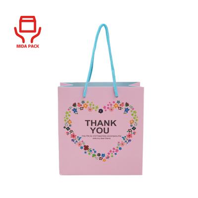 China Recyclable Custom Designs Matt Lamination Pink Kraft White Coated Cardboard Packaging Paper Shopping Bags With Tie Rope Handle for sale