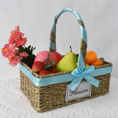 China Sustainable New Portable Water Grass Woven Storage Basket Rattan Flower Basket With Ribbons Fruit Snacks Camping Picnics Basket for sale