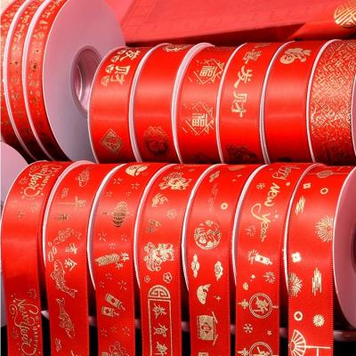 China Red shinny floral happy new year polyester satin ribbon 1inch 25mm custom logo gold foil printed satin ribbon for celebrate decoration for sale