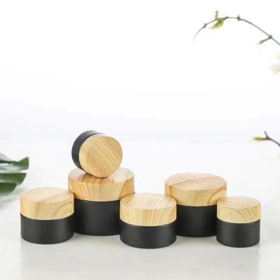 China Personal Care Frosted Black Glass Cosmetic Jar With Bamboo Style Plastic Lids for sale