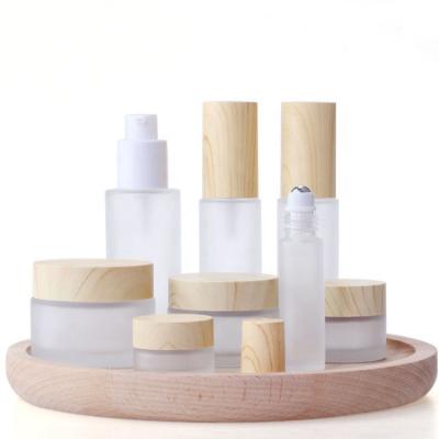 China Cosmetic Packaging 30ml 50ml 60ml 80ml 100ml 120ml Wooden Grain Water Transfer Grain Frosted Serum Pump Glass Bottles With Water Transfer Wood Lid for sale