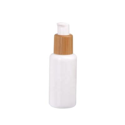 China 40ml base cosmetic opal glass cosmetic bottle with 20/410 bamboo wood plastic switch on-off lotion pump for sale