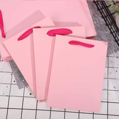 China Handmade custom luxury clothing retail bag packing gift bag bolsas de papel pink shopping packaging paper bags with handles for clothes for sale