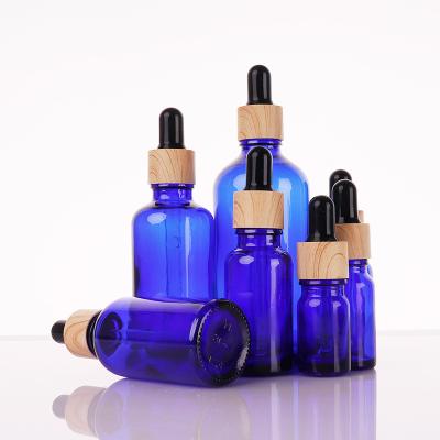 China 5ml 10ml 15ml 20ml 30ml 50ml 100ml cosmetic high quality blue color essential bottle with bamboo dropper cap for sale