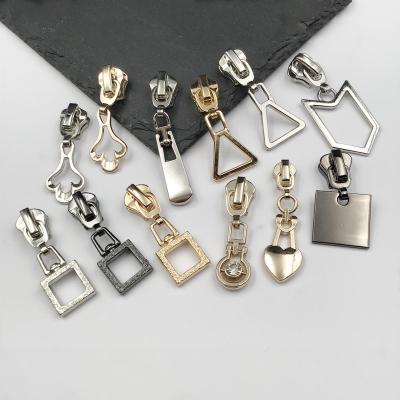 China Viable Custom Engraved Decorative Mental Logo Fashion Auto Lock Zipper Slider For Bag Clothes for sale