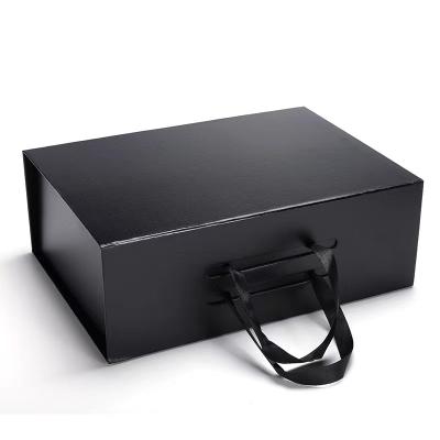 China Handmade Luxury Black Rigid Folding Cardboard Paper Box Customized Flip Magnetic Gift Box With Ribbon Handle for sale