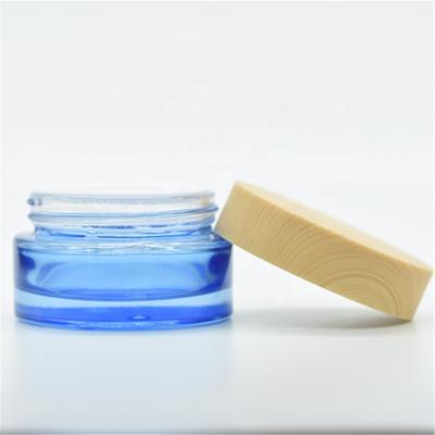 China LOW MOQ 20g 30g 50g Cosmetic Empty Round Blue Cream Glass Jars With Wooden Cap for sale