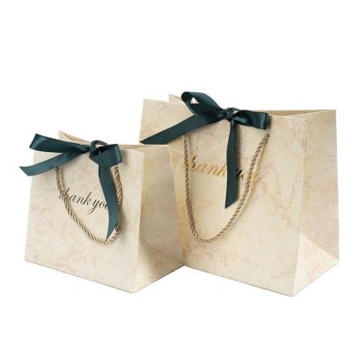 China Recyclable Makeup Printed Marble Gold Cosmetic Embossing Logo With Bow Paper Gift Thank You Bags for sale