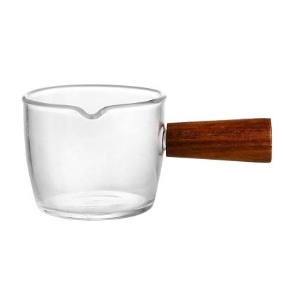 China High Viable Transparent Small Capacity Factory Borosilicate Glass Mouth Milk Cup Pot Heat Resistant Pot Two Measuring With Wooden Handle for sale