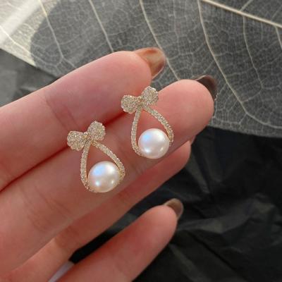 China FASHIONABLE Micro Zircon Bow Pearl Earrings Gold Plated Bow Shaped Shell Pearl Stud Earrings For Women for sale