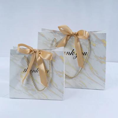 China 230g card festival marble texture flower gift disposable white paper bag with transparent lace ribbon bow tie knot for sale