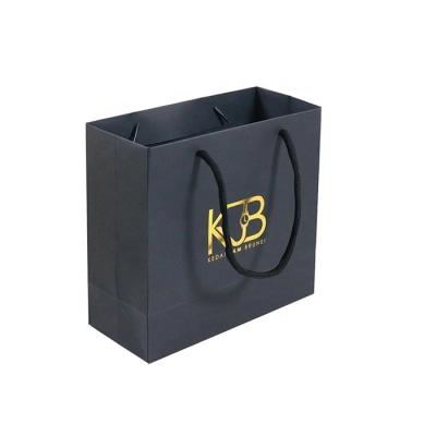 China Recyclable Gold Foiled Stamping Black Logo Hot Foiled Stamping Logo Card Kraft Paper Shopping Bag Recyclable Customized Paper Bag With Cotton Rope Handles for sale