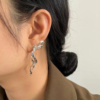 China Designer Liquid Silver Female Niche Earrings Fashion Bow Ribbon Needle High End Silver Stud Earrings for sale