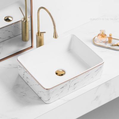 China Luxury Rectangular Above Counter Rim Sink Gold Bathroom Easy To Clean Gloss Rose Gold Line Wash Ceramic Basins With Faucet for sale