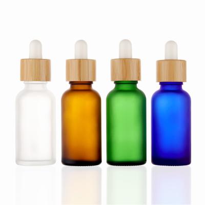 China Cosmetic 30ml 30ml 1oz 1oz Clear Glass White Blue Green Amber Frosted Dropper Bottles With Bamboo Screw Top For Essential Oil for sale