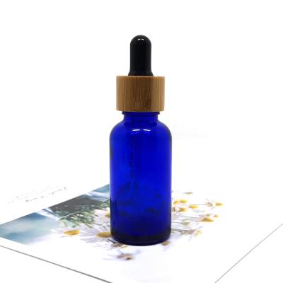 China Cosmetic Empty Cosmetic Glass Serum Lotion Packaging Cobalt Blue Essential Oil Dropper Bottles With Bamboo Tops for sale