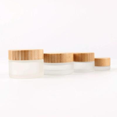 China 15ml 50ml 100ml eco-friendly recyclable cosmetic clear frosted glass cream jar with bamboo wooden lid for sale