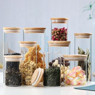 China Sustainable Borosilicate Glass Storage Jar With Lid Bamboo Wooden Tube Shaped Airtight Glass Container For Food Multigrain Nut Tea Leaves for sale