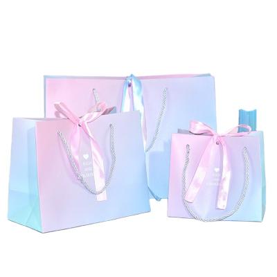 China Recycled materials 2021 new white card packagingcarrier bag with pp handle, custom logo printed gradient paper gift shopping bag for wholesale for sale