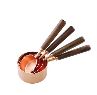 China PSC 4 Stainless Steel Sustainable Rose Gold Measuring Cups And Spoon Set With Wooden Handle for sale