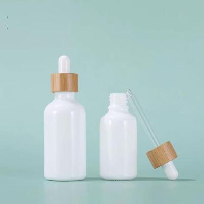 China Good Quality 5ml 10ml 15ml 20ml 30ml 50ml 100ml White Essential Oil Bottle Cosmetic Glass Dropper Bottle With Bamboo Lid for sale