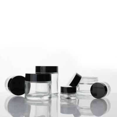 China Wholesale 10g 30g 60g 100g Cream Glass Empty Clear Cosmetic Glass Jars Jar With Black Plastic Lids Caps For Skin Care for sale