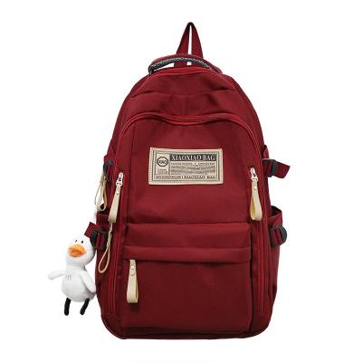 China Waterproof high school large capacity school bag simple travel computer backpack leisure solid color label backpack for sale