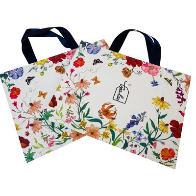 China Recycled Materials Custom Printed Thick Cosmetic Brand Shopping Paper Bag With Black Ribbon Handle for sale