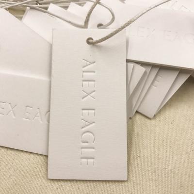 China Sustainable Custom Embossed Logo Paper Garment Clothing Hang Tag For Jeans Clothing Hang Tags for sale