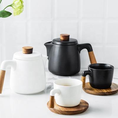 China Viable Nordic creative simple ceramic tea set with acacia wood handle ceramic teapot white black cup and wood saucer customized logo for sale