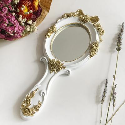 China Personalized Vintage Rose Carved Makeup Mirror Princess European Palace Style Small Hand Held Cosmetic Vanity Mirror for sale