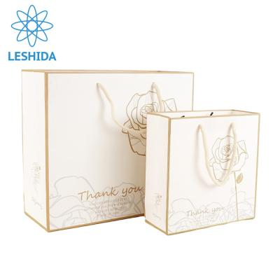 China Recyclable Luxury Shopping Paper Bag Customize Logo Dress Packaging Bags Gift Paper Bag With Rope Handles for sale