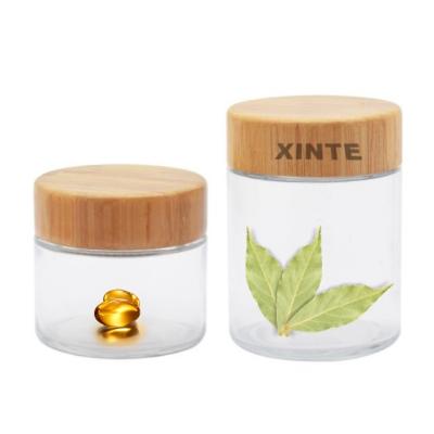 China Factory price cosmetic high quality lightweight glass jar with wooden cap lid for sale decal screen printing offset printing hot stamping for sale