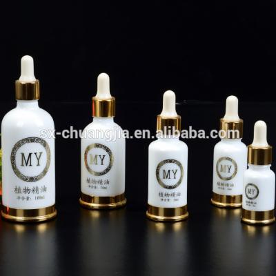 China Recyclable Cosmetic Gold Base Metal Essential Oil Glass Opal White Bottle Packaging With Dropper Bottle Screen Printing Serum Bottle for sale