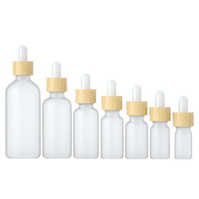 China Round 30ml cosmetic matte frosted clear glass dropper bottle with wooden bamboo dropper lids for sale