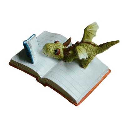 China Europe Z12188A Cute Miniature Home Decor Cartoon Reading Dragon Statue Gift Figure Resin Figurine Animal for sale