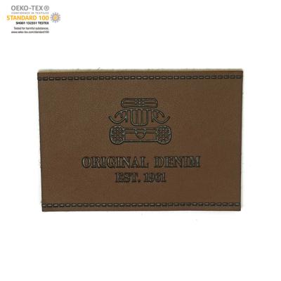 China Durable Metal Foil Embossed Logo On Jeans PU Label Simple Pattern Good Quality for sale