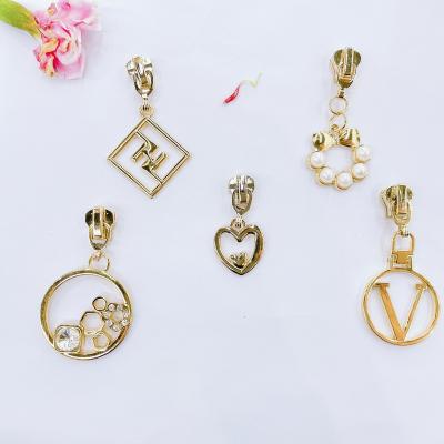 China Other Custom All Kinds Wear Resistant Golden Light Metal Hanging Zipper Slider , Custom Logo Zipper Puller For Bags Clothes Handbags for sale