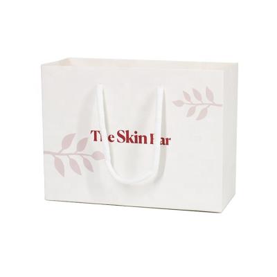 China Recyclable Small Fashion White Cosmetic Carry Gift Paper Bag With Printed Logo for sale